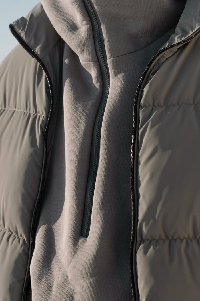 A detailed view of a gray puffer jacket, showcasing its texture and design.